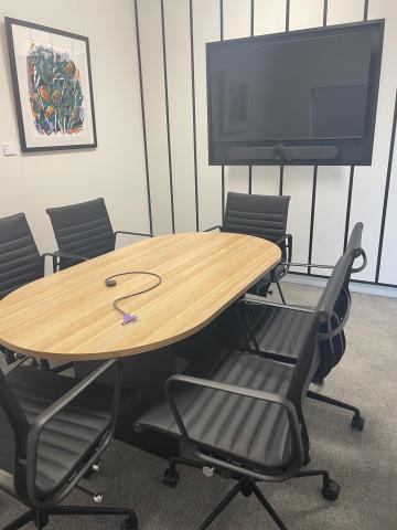 Meeting room with table, chairs and television screen 